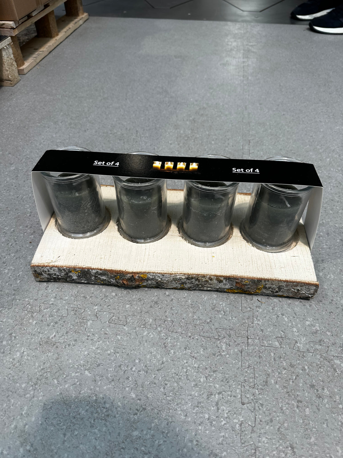 Set aus Holzplatte und vier grauen Glaswindlichtern